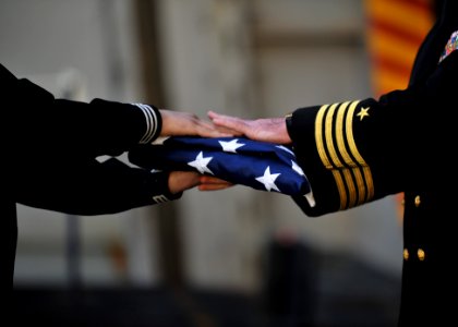 A Sailor hands off a flag during a burial at sea. (8203274860)
