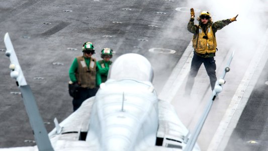 A Sailor directs an F A-18C Hornet. (18861874022)
