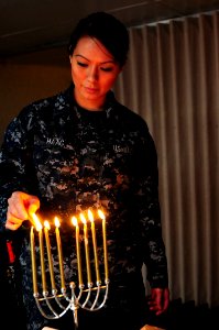 A Sailor lights a minorah at sea. (8284405714)