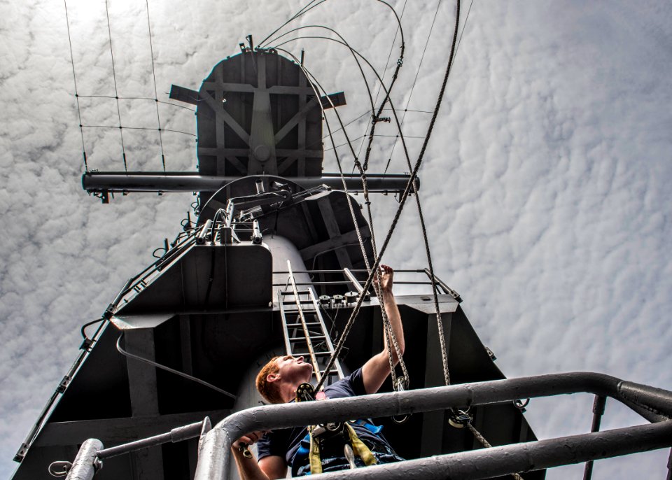 A Sailor lowers lines on the aft mast of USS Essex. (20187731109)