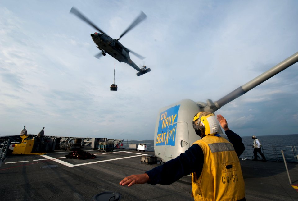 A Sailor directs an MH-60S at sea. (8270222968)