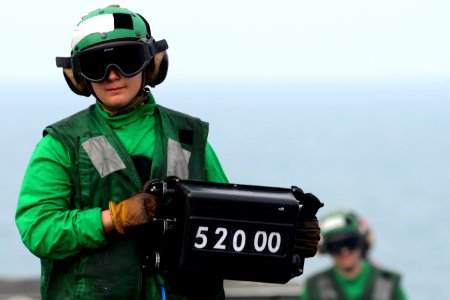 A Sailor displays an aircraft's weight before launch