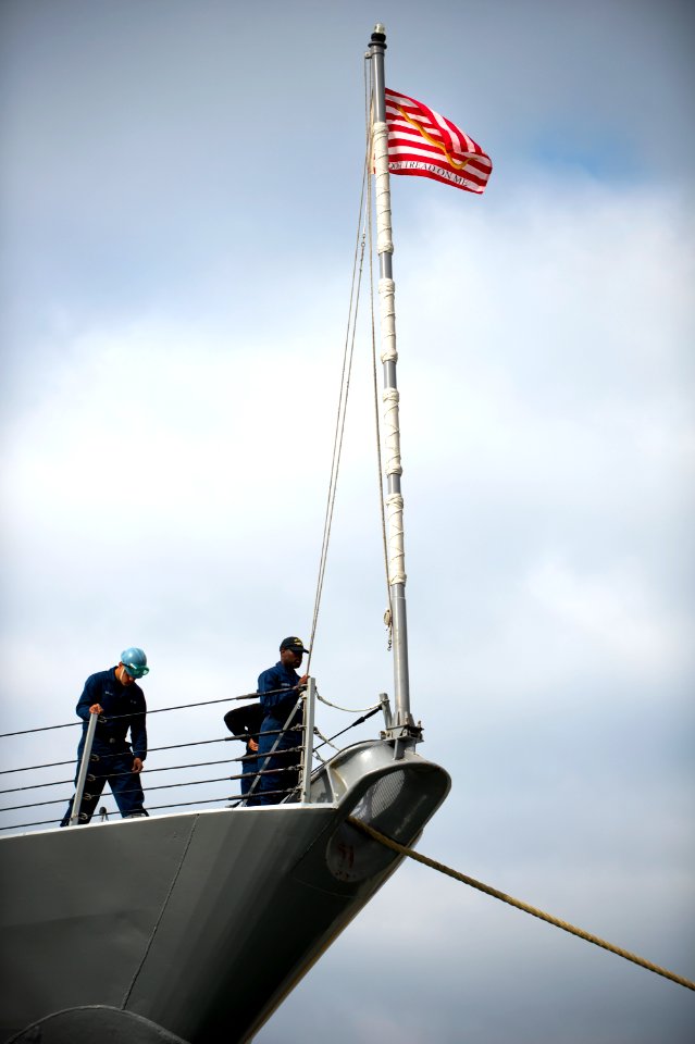 A Sailor lowers the Navy Jack. (8456179442)