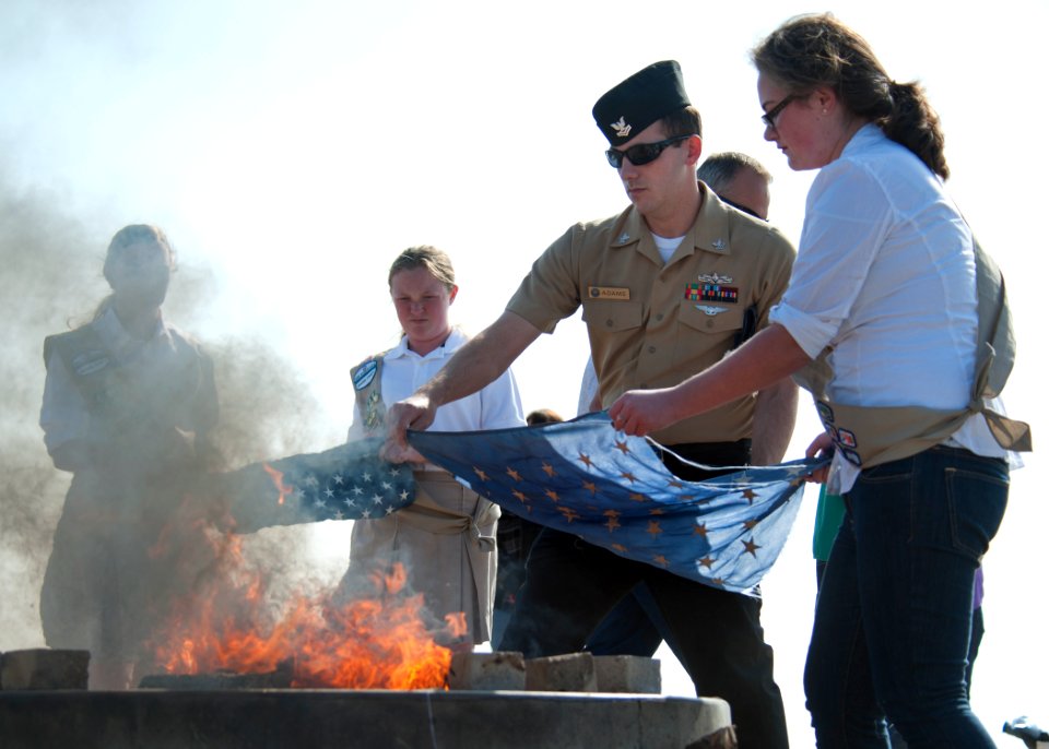 A Sailor helps retire a flag. (8573734589)