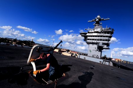 A Sailor installs a gasket on a hatch. (8428933703)