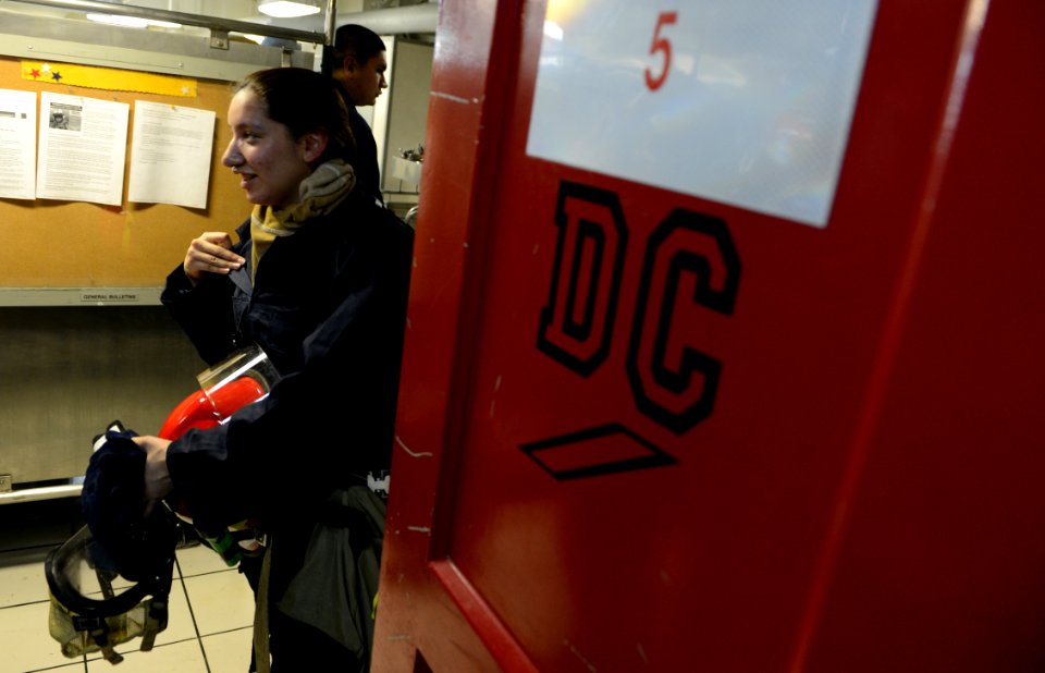 A Sailor removes fire fighting gear during a drill. (8426063347)