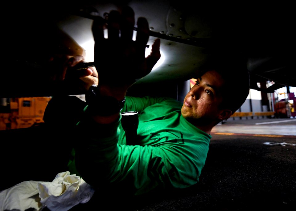 A Sailor removes a panel from the bottom of an MH-60S Sea Hawk helicopter. (41670072461)