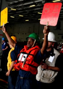 A Sailor signals during a replenishment-at-sea. (8199142117)