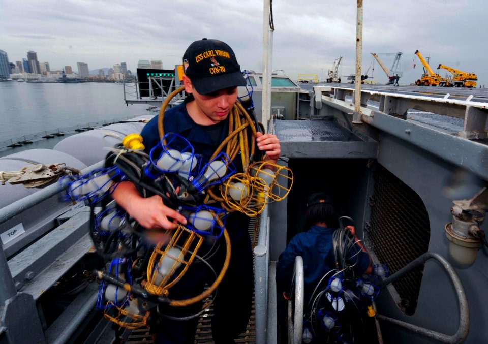 A Sailor removes lights from the flight deck. (8427151956)