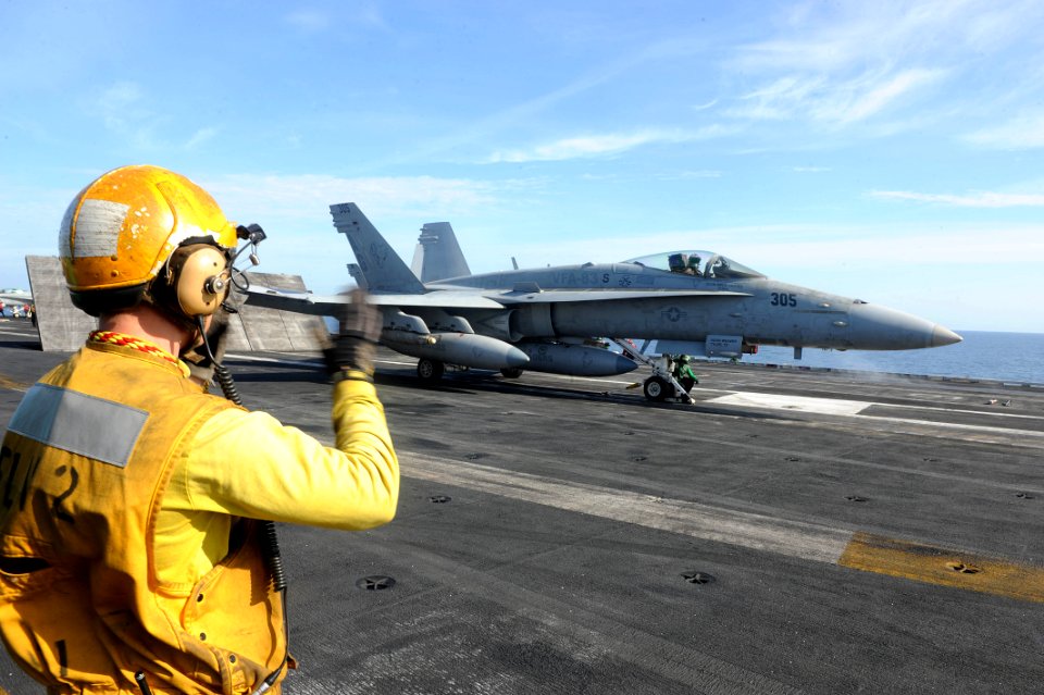 A sailor signals to an F A-18C Hornet. (8701367839)
