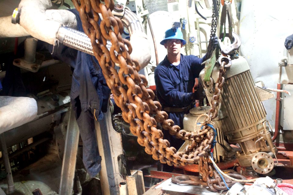 A Sailor removes equipment from the former USS Guardian. (8592538600)