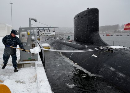 A Sailor shovels snow beside USS Missouri. (8468330658)