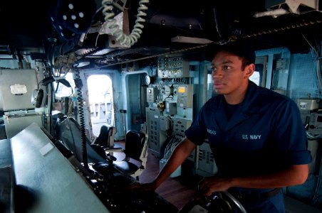 A Sailor steers USS Mustin at sea. (8181976926)