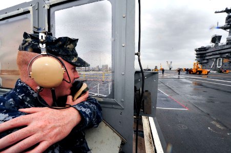 A Sailor talks on a sound-powered phone. (8426060691)