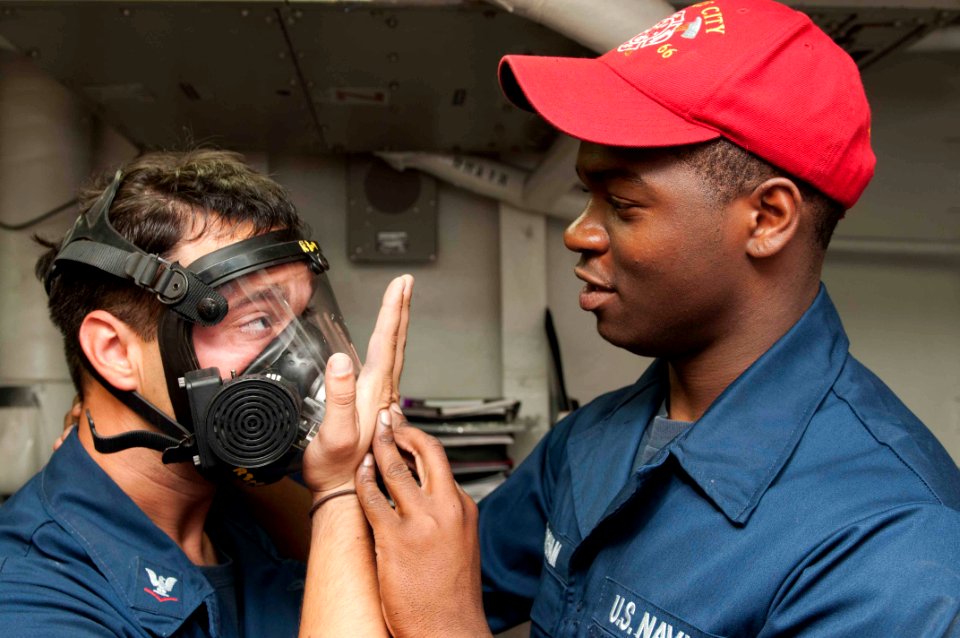 A Sailor tests the seal on his gas mask. (8202178971)