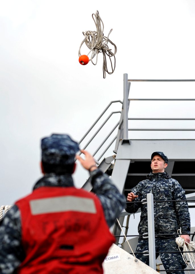 A Sailor tosses a messenger line back to the ship. (8426061677)