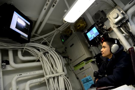 A Sailor watches flight deck activity from the hangar bay. (8427152702)