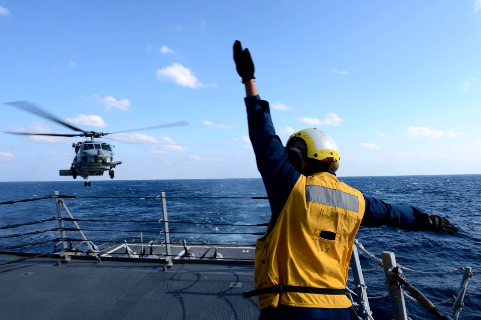 A Sailors signals to an SH-60B Sea Hawk helicopter. (8530740319)