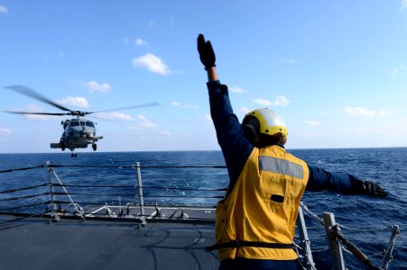 A Sailors signals to an SH-60B Sea Hawk helicopter. (8530740319)