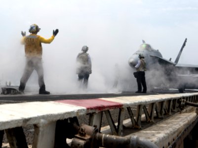 A Sailors guides an F-A-18C onto a catapult at sea. (8580533514)
