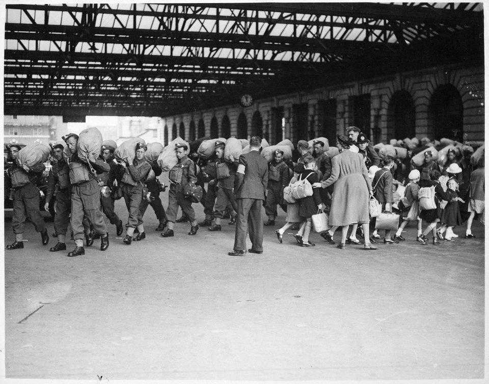 A scene at a London railway station showing troops arriving while kiddies who are being evacuated from London leave... - NARA - 541921