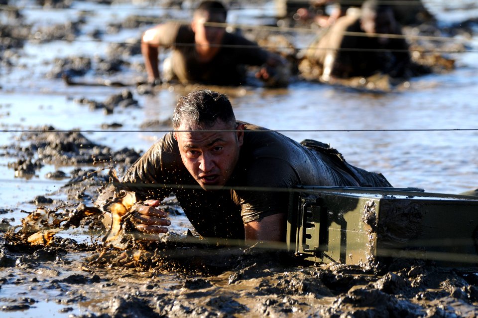A Seabee crawls through an obstacle course. (8185197769)