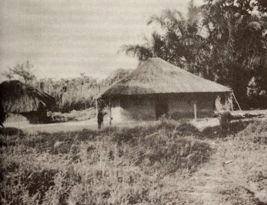 A square-shaped, thatched- roof hut, typical of the Kasai-Oriental Region, provides shelter against the heavy rains
