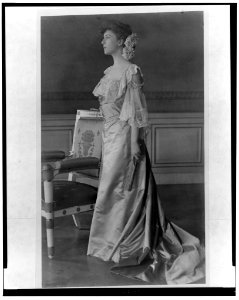 Alice Roosevelt Longworth, full-length portrait, standing next to chair, facing left LCCN2002713060