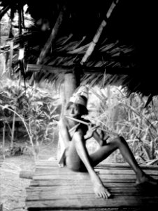Alipio, en chocógosse, blåser flöjt. Han bär en huvudprydnad av palmblad. Rio Sambú, Darién, Panamá - SMVK - 004080