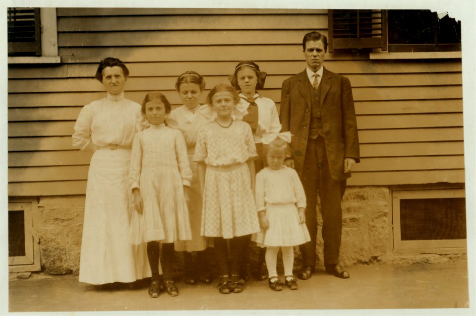 All of the family of Antoinette Pothier, 32 Easton Street, (See 2477). Father and tallest girl in back row of the picture work. Antoinette is the center of the group in the front row. Her LOC nclc.02346