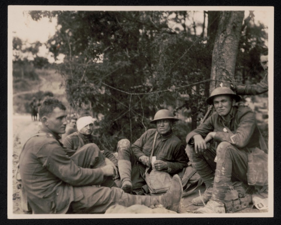 Allied soldiers, one with a bandaged head, sitting on the ground during World War I LCCN2017645503