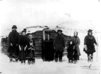Barn og voksne skoltesamer foran hus, Neiden, Sør-Varanger, Finnmark, ca. 1904 - Norsk folkemuseum - NF.06725-023