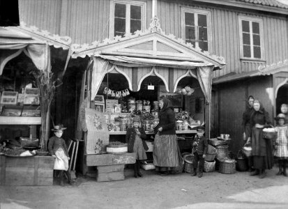 Barn och kvinnor framför Charlotta Forsbergs karamellstånd i Strömstad, 1890-tal - Nordiska Museet - NMA.0048371