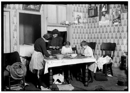 143 Hudson St., ground floor. Mrs. Salvia; Joe, 10 years old; Josephine, 14 years old; Camille, 7 years old. Picking nuts in a dirty tenement home. The bag of cracked nuts (on chair) had LOC nclc.05479