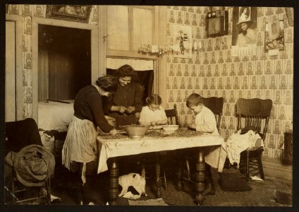 143 Hudson St., ground floor. Mrs. Salvia; Joe, 10 years old; Josephine, 14 years old; Camille, 7 years old. Picking nuts in a dirty tenement home. The bag of cracked nuts (on chair) had LOC nclc.05479