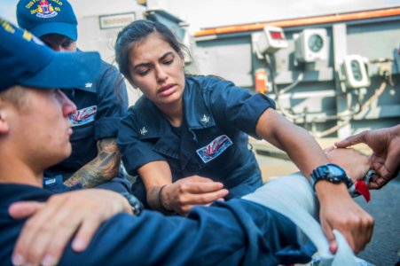 150413-N-XM324-040 - PO3 Christina Casillas applies a splint to a simulated broken arm aboard USS Fitzgerald photo