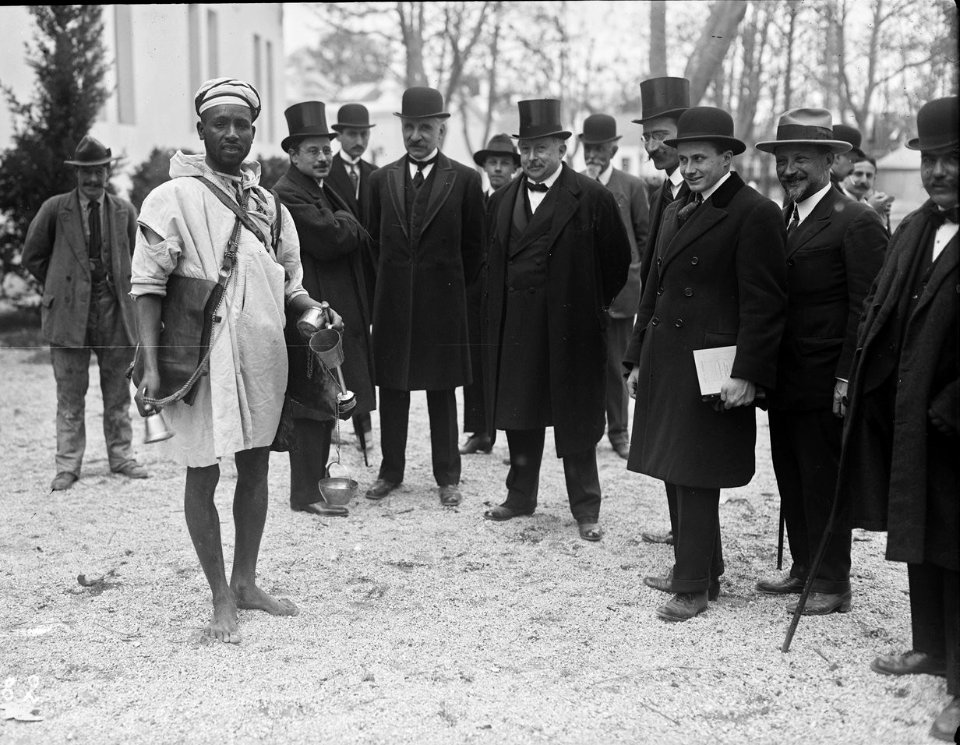 16-4-22, exposition (coloniale) de Marseille, un porteur d'eau, (M. Lucien) Dior (avec un noeud papillon, lors de l'inauguration) - (photographie de presse) - (Agence Rol)