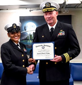 170427 - CAPT Fortson gives CMDCM Holliday honorable discharge certificate