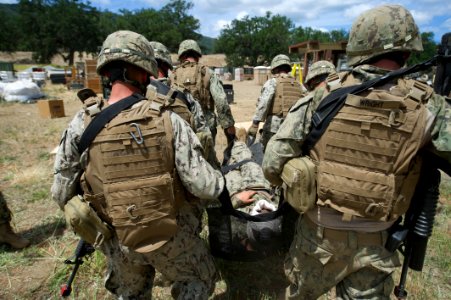 170514-N-XJ502-084 - Seabees assigned to Naval Mobile Construction Battalion (NMCB) 4 perform a six-man litter carry