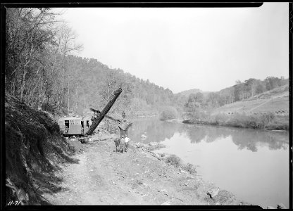 Power shovel at work on roadway at Norris Dam site on the Clinch River. The steep hillsides are characteristic of... - NARA - 532695 photo