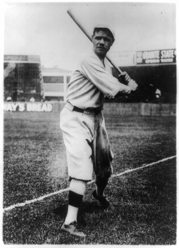 Babe Ruth, full-length portrait, standing, facing front, holding up bat, in baseball uniform, on field LCCN89714713