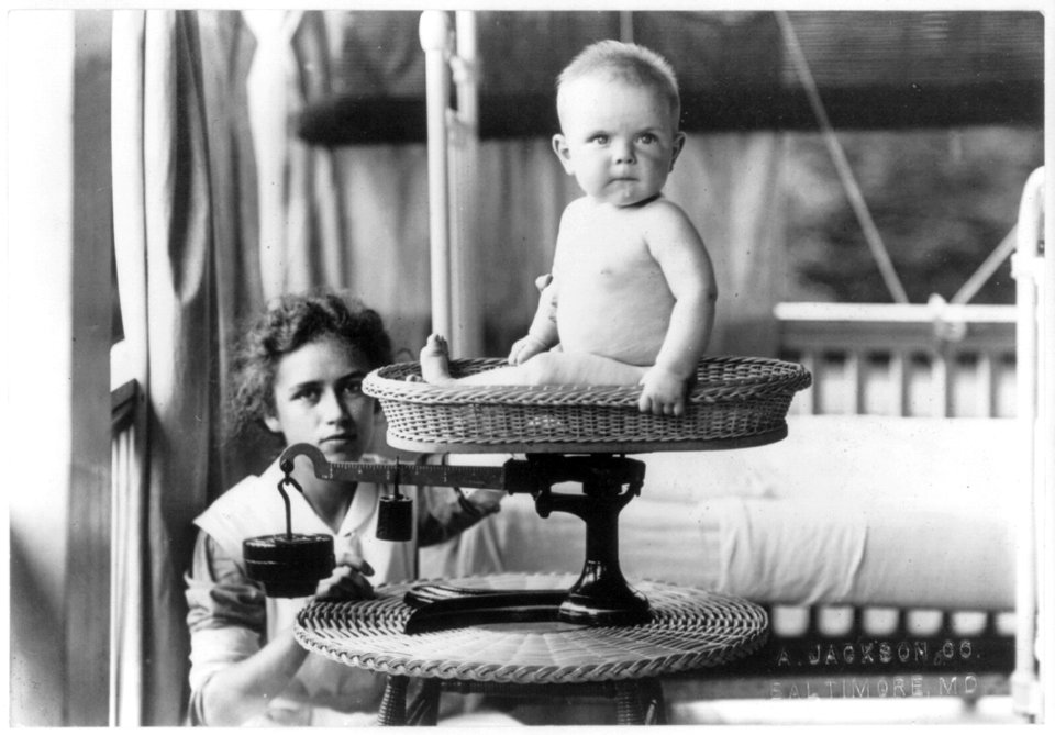 Baby being weighed by nurse on scale LCCN2006684396