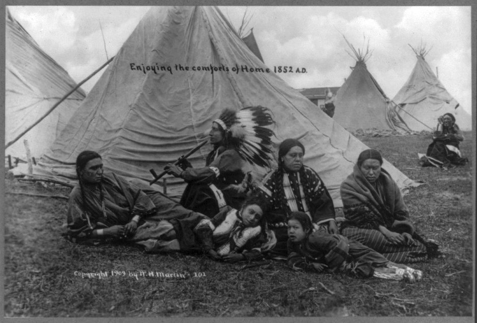 American Indians enjoying the comforts of home; posed family group outside tepee; one smoking pipe LCCN2007681682