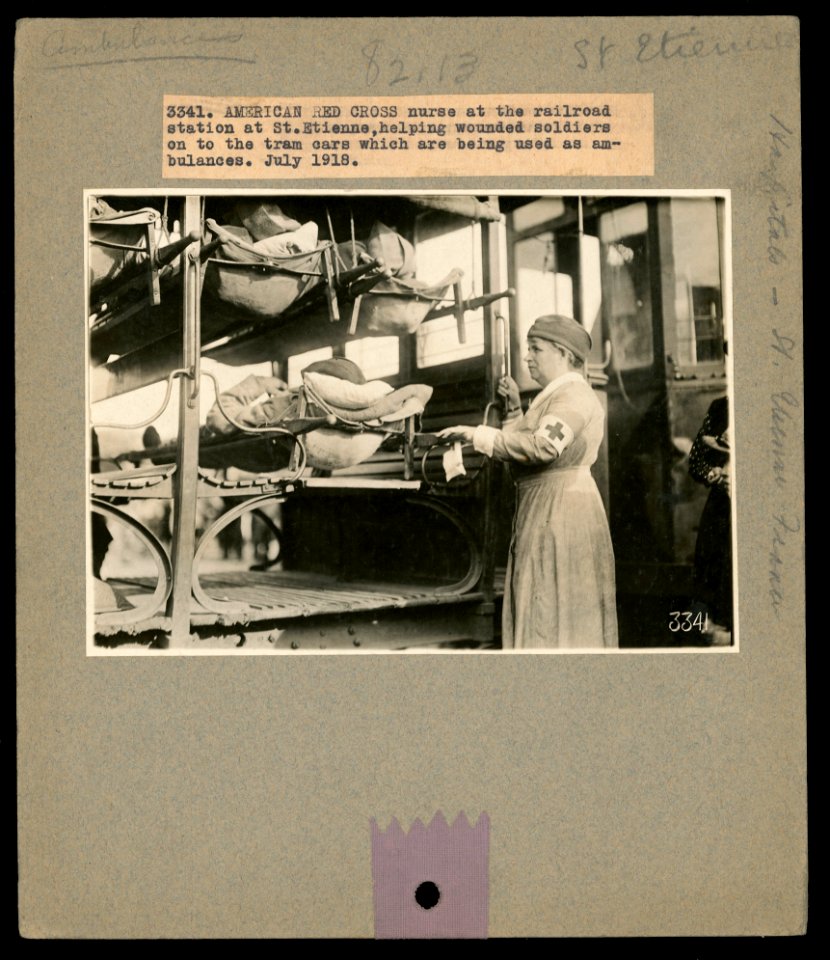 American Red Cross nurse at the railroad station at St. Etienne, helping wounded soldiers on to the tram cars which are being used as ambulances, July 1918 LCCN2016645646