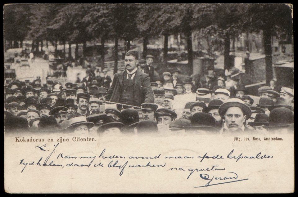 Amstelveld. Standwerker Meijer Linnewiel, alias Kokadorus (1867-1934) tussen zijn klanten. Uitgave Jos Nuss, amsterdam, Afb PBKD00253000001