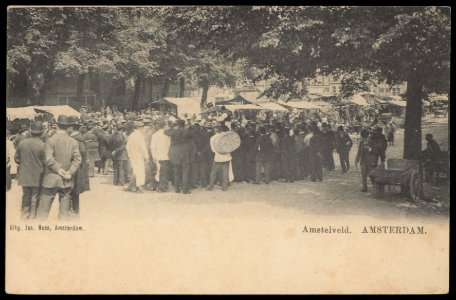 Amstelveld. Standwerker Meijer Linnewiel, alias Kokadorus (midden) tussen zijn klanten. Uitgave Jos Nuss, Amsterdam, Afb PBKD00253000005