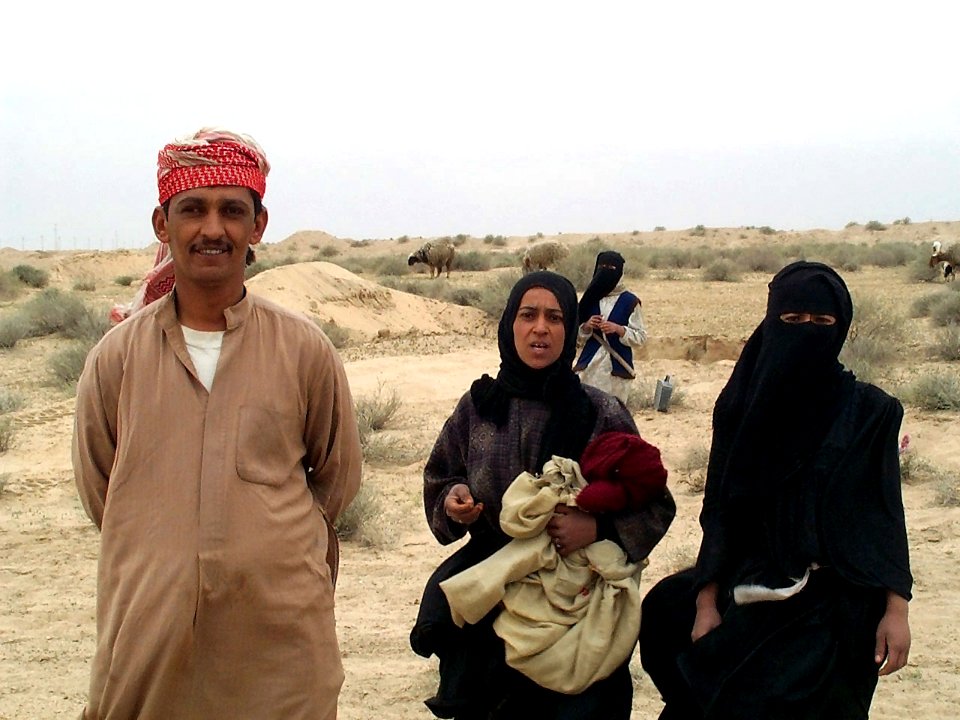 An Iraqi man and two Iraqi women stop and pose for a picture somewhere between Safwan and Umm Qasr DM-SD-04-16848