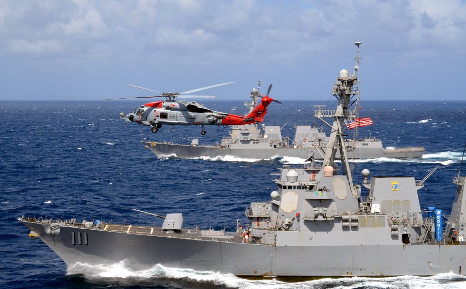 An MH-60R Seahawk flies over the guided-missile destroyers USS Spruance and USS Momsen. (28434294795)