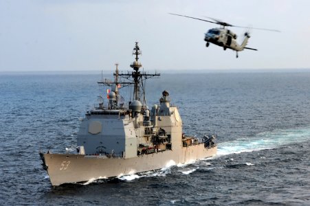 An MH-60S flies above USS Mobile Bay. (8498339624)