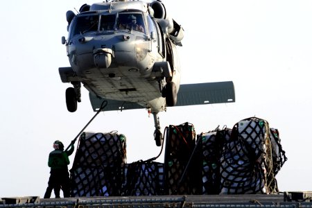 An MH-60S picks up supplies at sea. (8270225382)